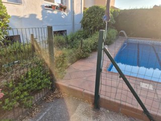Valla metálica para piscina con puerta y postes.