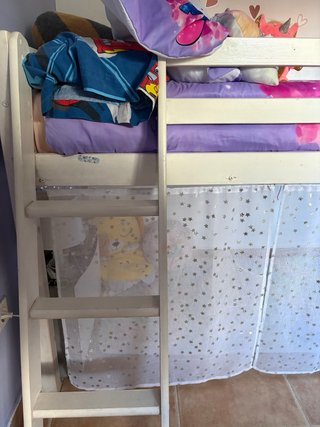 Cama alta con cortinas de estrellas