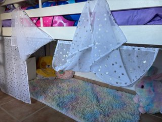 Cama alta con cortinas de estrellas