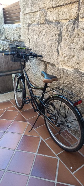 Bicicleta de paseo negra con cesta extraíble.