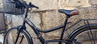 Bicicleta de paseo negra con cesta extraíble.