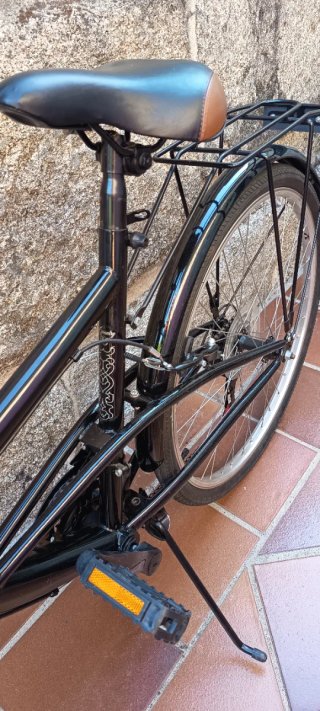 Bicicleta de paseo negra con cesta extraíble.