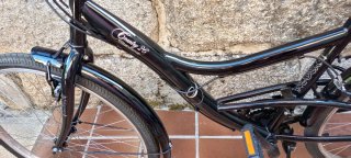 Bicicleta de paseo negra con cesta extraíble.