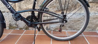 Bicicleta de paseo negra con cesta extraíble.