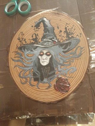 Dibujo bruja en tronco de madera