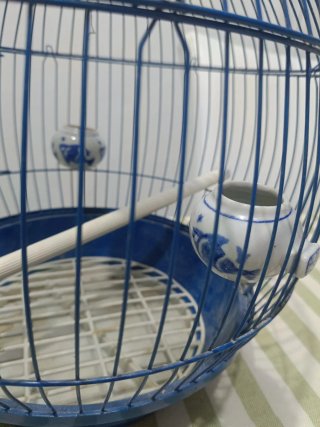 Jaula para pájaros azul con comederos