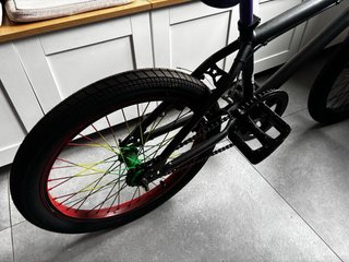 Bicicleta BMX negra con ruedas de colores