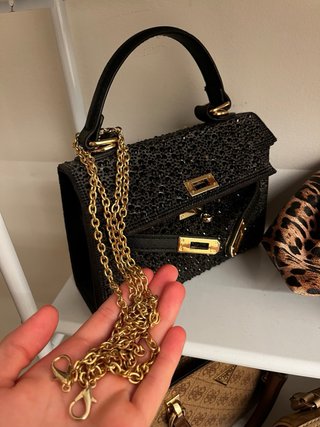 Bolso de mano negro con detalles dorados