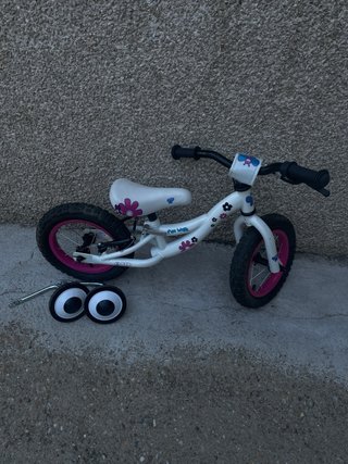 Bici de aprendizaje blanca con ruedas rosas
