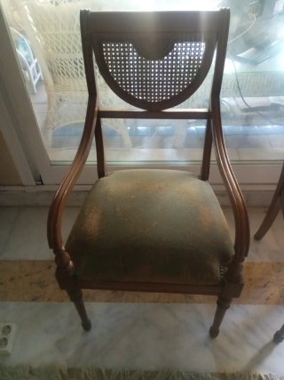 Sillones de nogal y cuero con respaldo en rejilla.