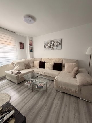 Sofá modular beige y mesa centro cristal