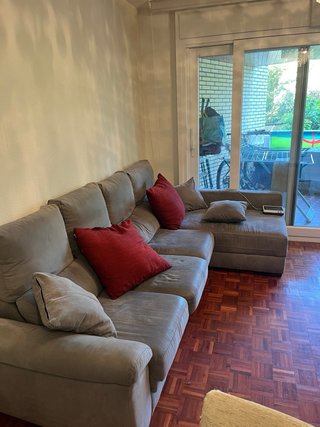 Sofá modular gris con cojines rojos