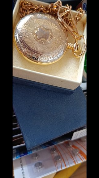 Reloj de bolsillo dorado con moneda