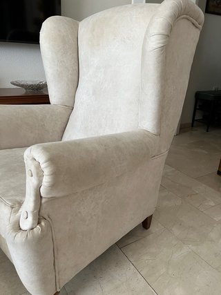 Sillón orejero clásico beige con reposapiés