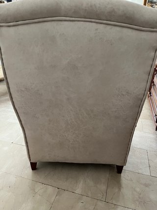 Sillón orejero clásico beige con reposapiés