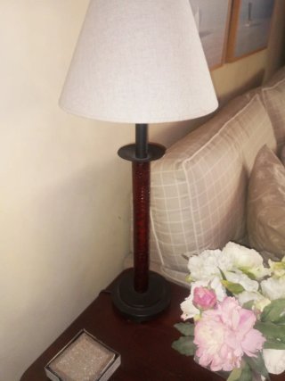Lámpara de mesa con pie de metal y labrado.