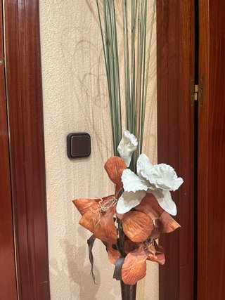 Jarrón metálico con flores decorativas