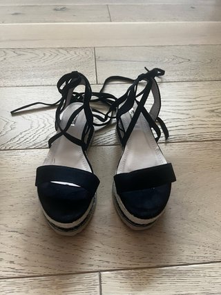 Sandalias cuña negras atadas a pierna