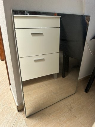 Mueble de baño con lavabo, grifo y espejo.