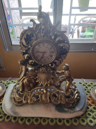 Reloj de bronce antiguo con figuras