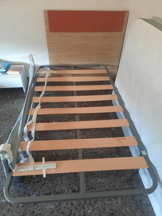 Cama individual con cabecero de madera.