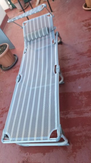 Tumbona plegable gris y blanca
