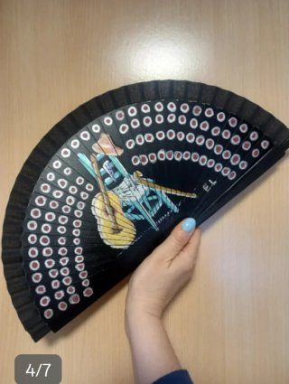 Abanico negro con dibujo de silla y guitarra