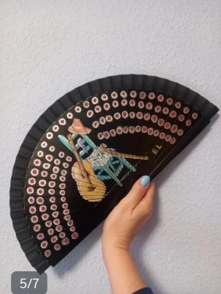 Abanico negro con dibujo de silla y guitarra