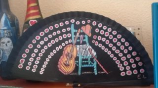 Abanico negro con dibujo de silla y guitarra