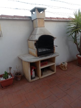 Conjunto mesa, bancos de piedra y barbacoa.