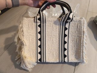 Bolso de tela beige y negro con flecos