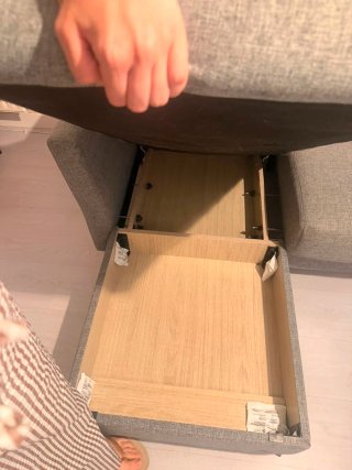 Sofá cama gris con cojines rojos