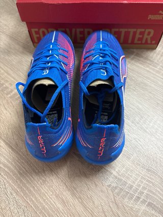 Botas de fútbol Puma Ultra azules y rosas.