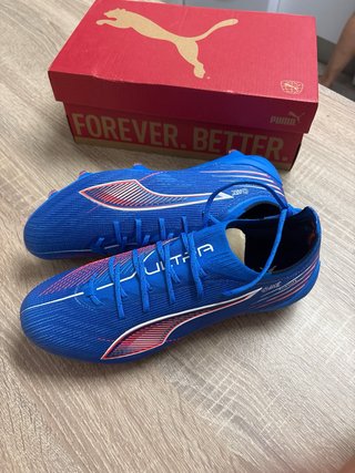 Botas de fútbol Puma Ultra azules y rosas.