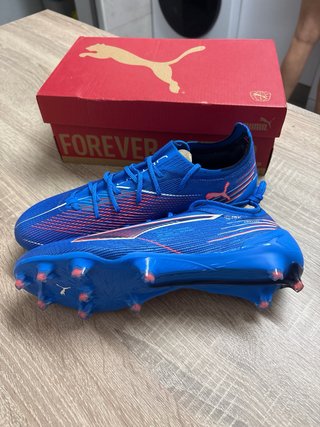 Botas de fútbol Puma Ultra azules y rosas.
