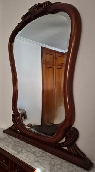 Elegante espejo de tocador con marco de madera.