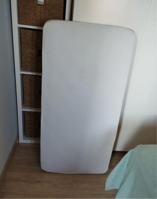Cuna de madera con ropa de cuna