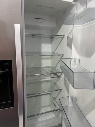 Nevera grande y plateada con una pieza rota