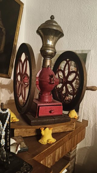 Molino de café antiguo con ruedas