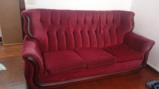 Sofá de terciopelo rojo con detalles de madera