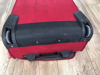 Maleta de viaje roja con ruedas, con daño en tela