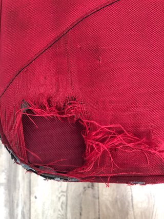 Maleta de viaje roja con ruedas, con daño en tela