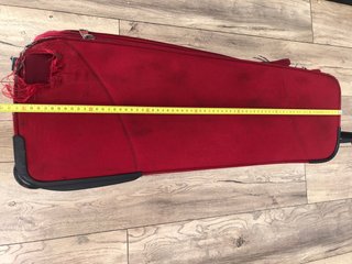Maleta de viaje roja con ruedas, con daño en tela
