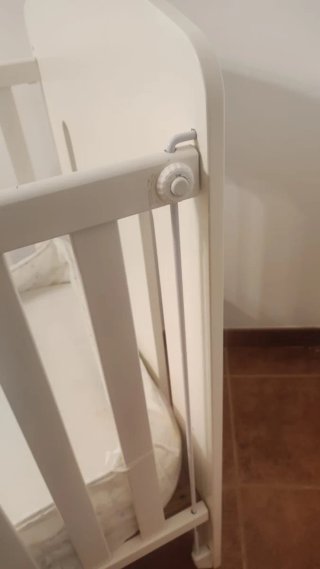 Cuna de bebé blanca con colchón.