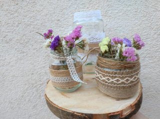 Botes de vidrio decorados y rodajas de madera.