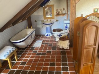 Casa de muñecas de piedra y madera