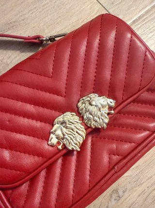 Precioso bolso rojo con detalles de leones dorados