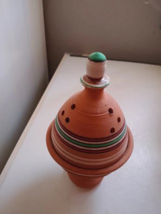Figura decorativa de barro con detalles rojos