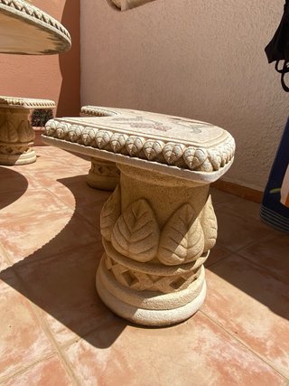 Mesa y bancos de piedra tallada con mosaico