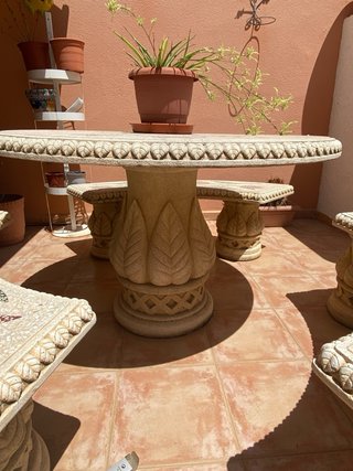 Mesa y bancos de piedra tallada con mosaico